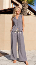 Front view of woman wearing grey sleeveless vest and wide-leg pants set outdoors