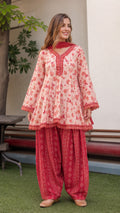 Front view of model wearing peach floral peplum tunic and red dhoti pants