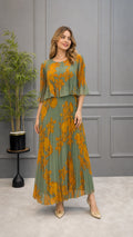 Front full-length view of model wearing sage green pleated floral maxi dress with layered ruffle bodice