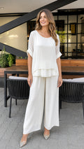 Model wearing white layered tunic and wide-leg pants set, front view