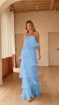 Front full-length view of woman wearing strapless sky blue tiered fringe maxi dress