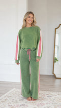 Front view of model wearing the Sage Green vintage washed sweatshirt and wide-leg sweatpants set with pink side stripes