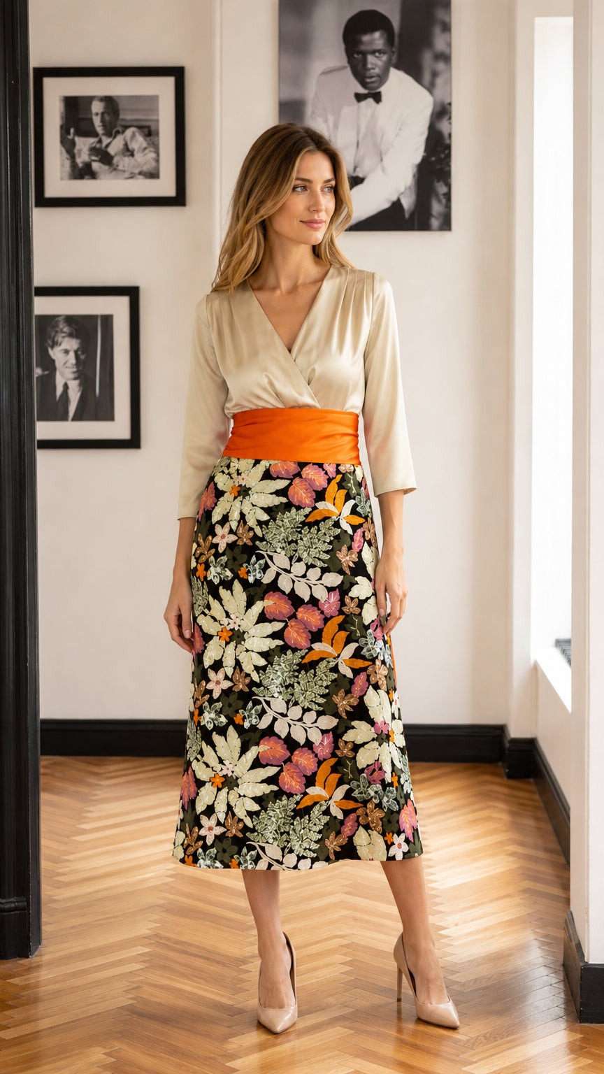 Full front view of model wearing cream and black floral midi dress with orange sash
