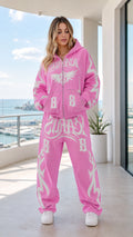 Front view of model wearing pink Y2K graphic zip-up hoodie and sweatpants set