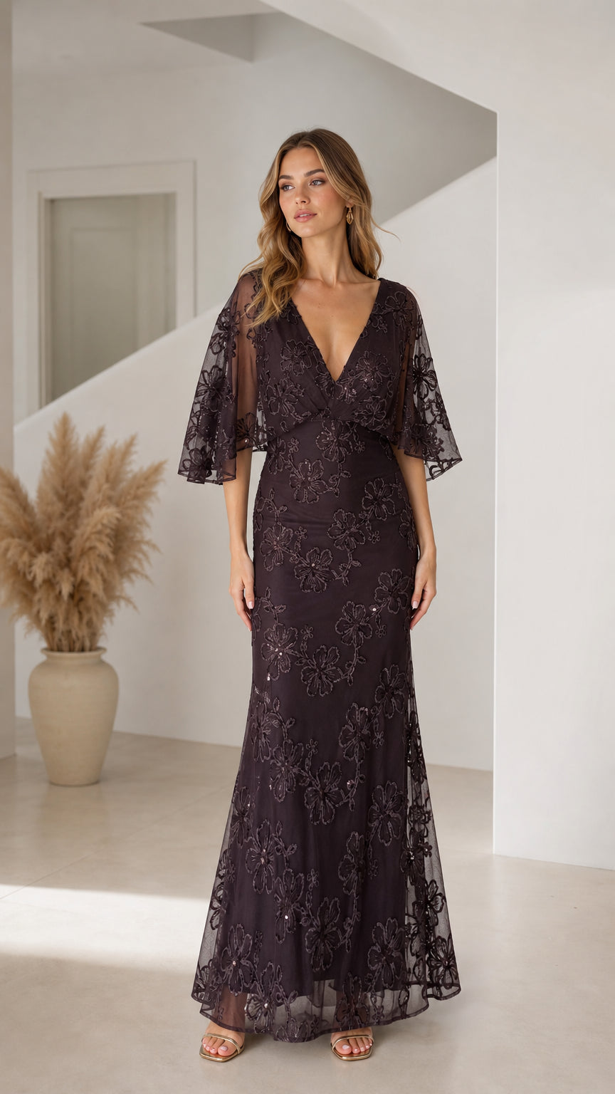 Front view of woman wearing dark plum floral sequin flutter sleeve maxi evening dress