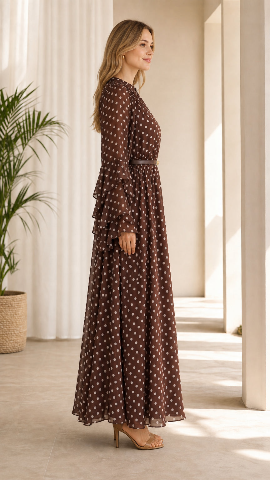 Side profile view of model in brown polka dot tiered ruffle sleeve maxi dress