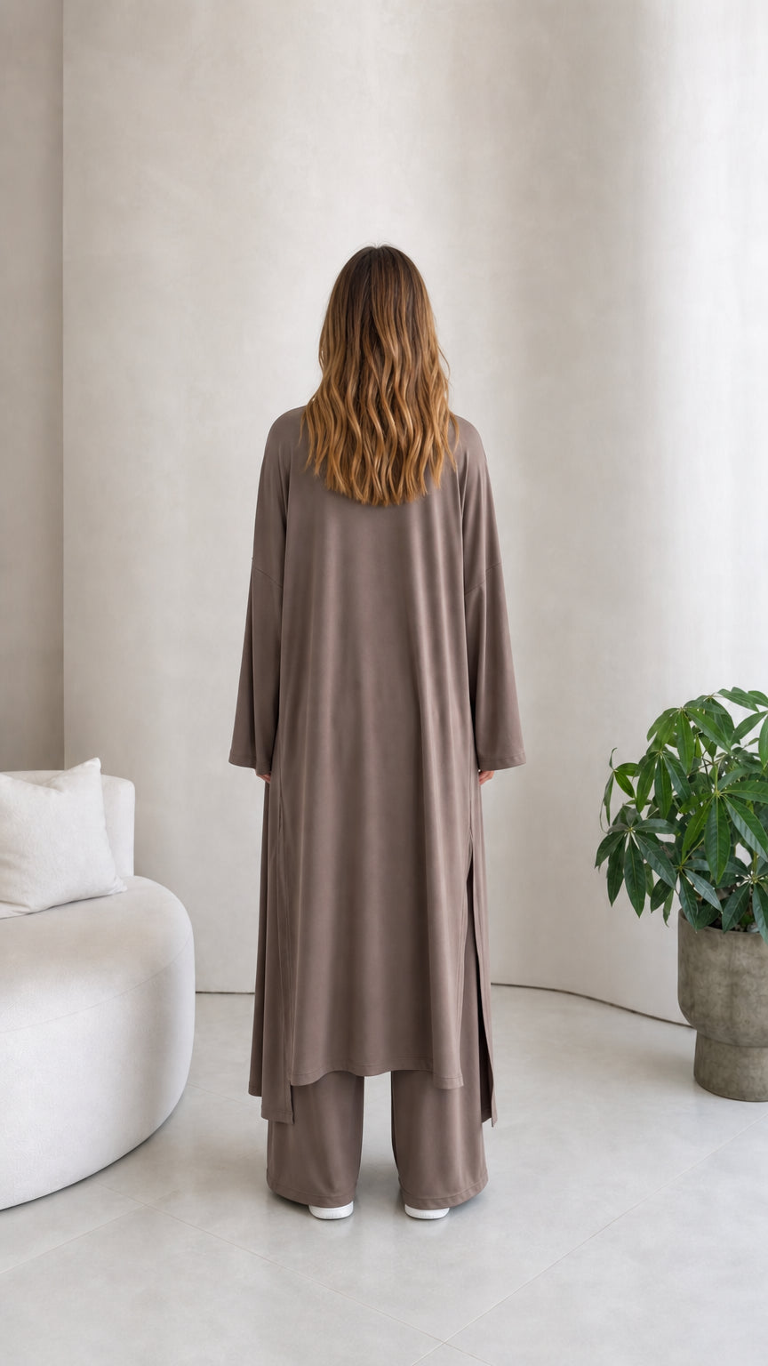 Back view of model wearing the longline duster cardigan and wide-leg pants in taupe