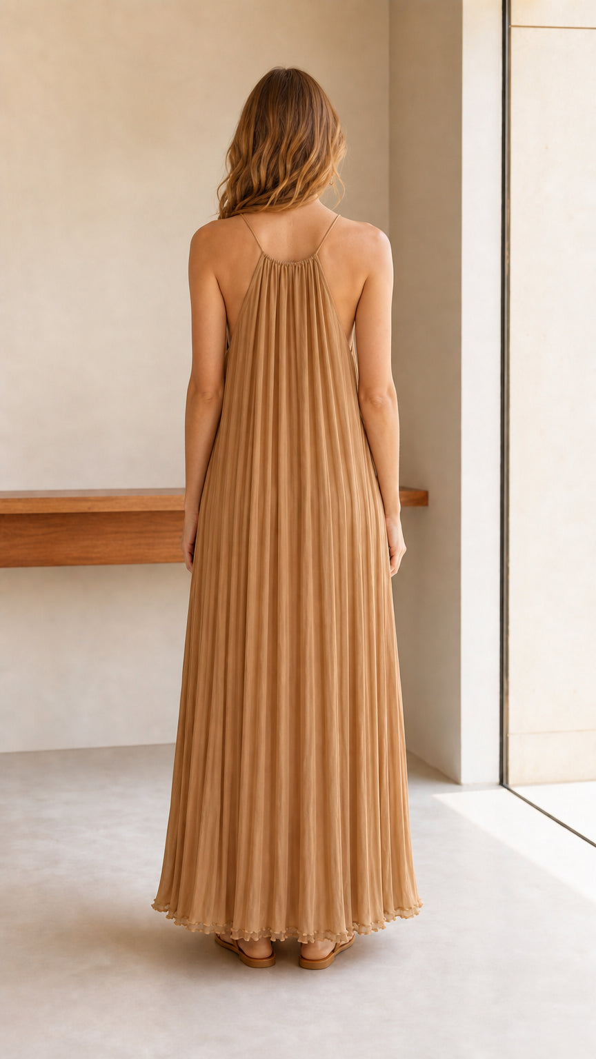 Model wearing camel pleated halter maxi dress, back view