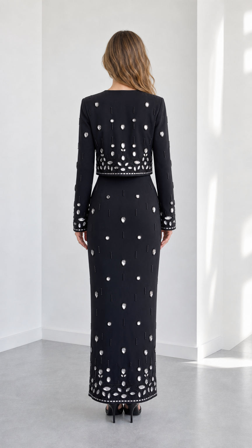 Back view of black rhinestone embellished two-piece evening set showing column skirt