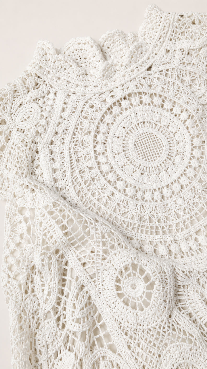 Close-up detail of white geometric crochet lace fabric and mock neck