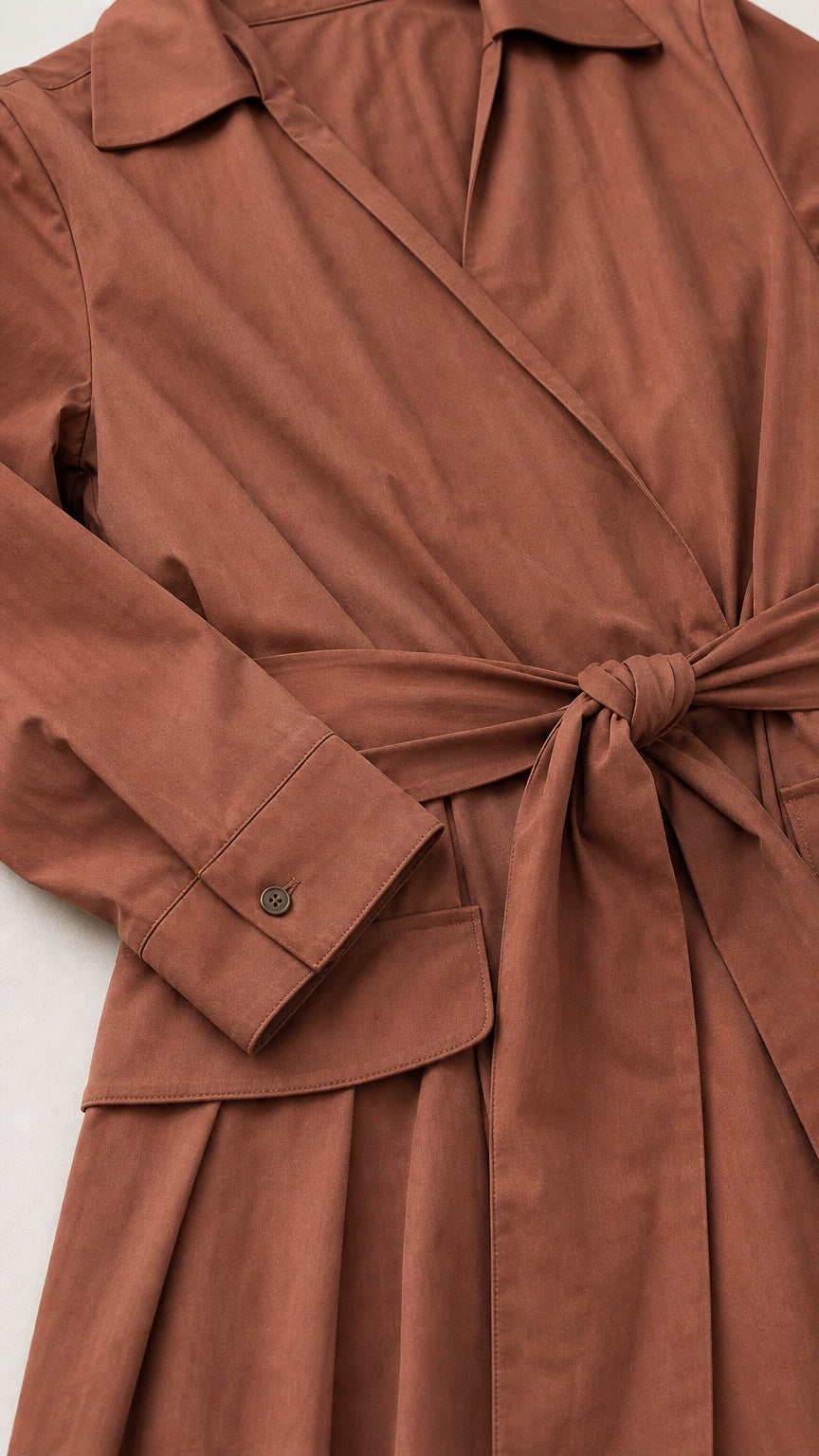 Close up of collar, belt, and cuff details of brown trench dress