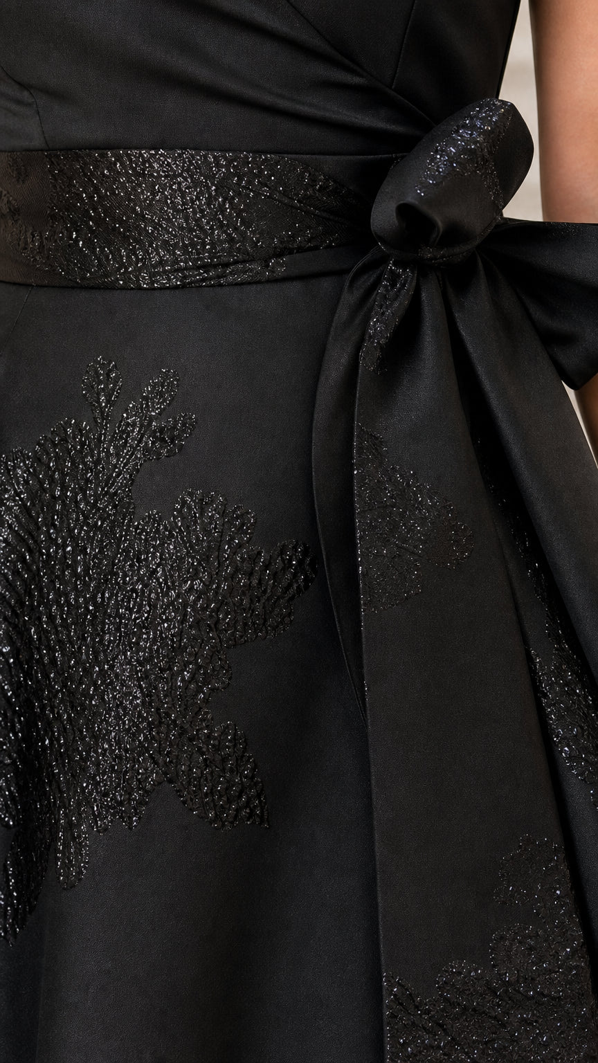 Close-up of embellished waist belt and embroidery on black dress