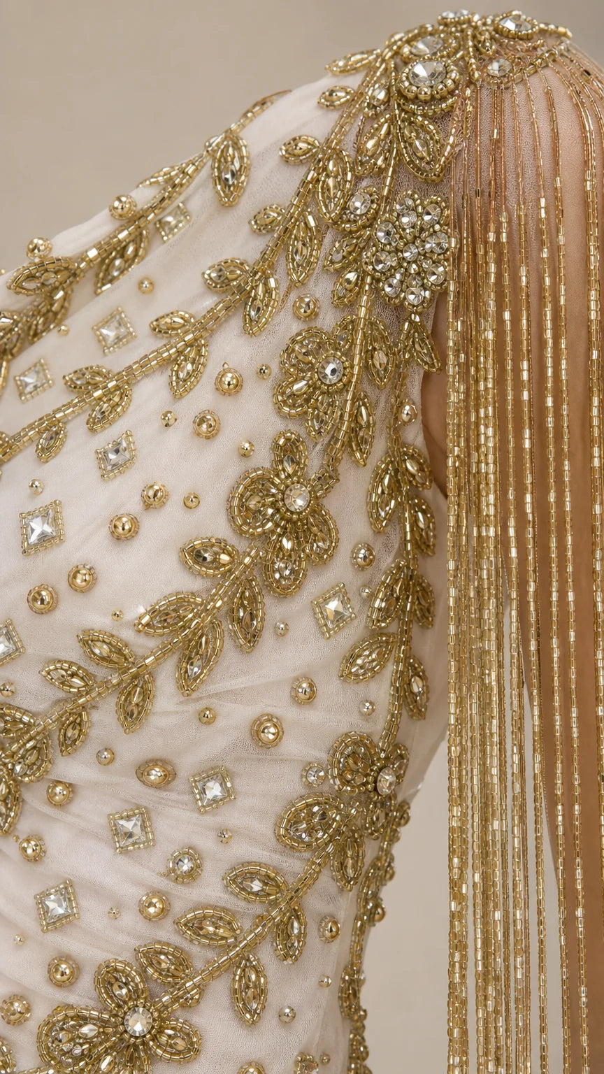 Close-up detail of gold embroidery and fringe on gown shoulder