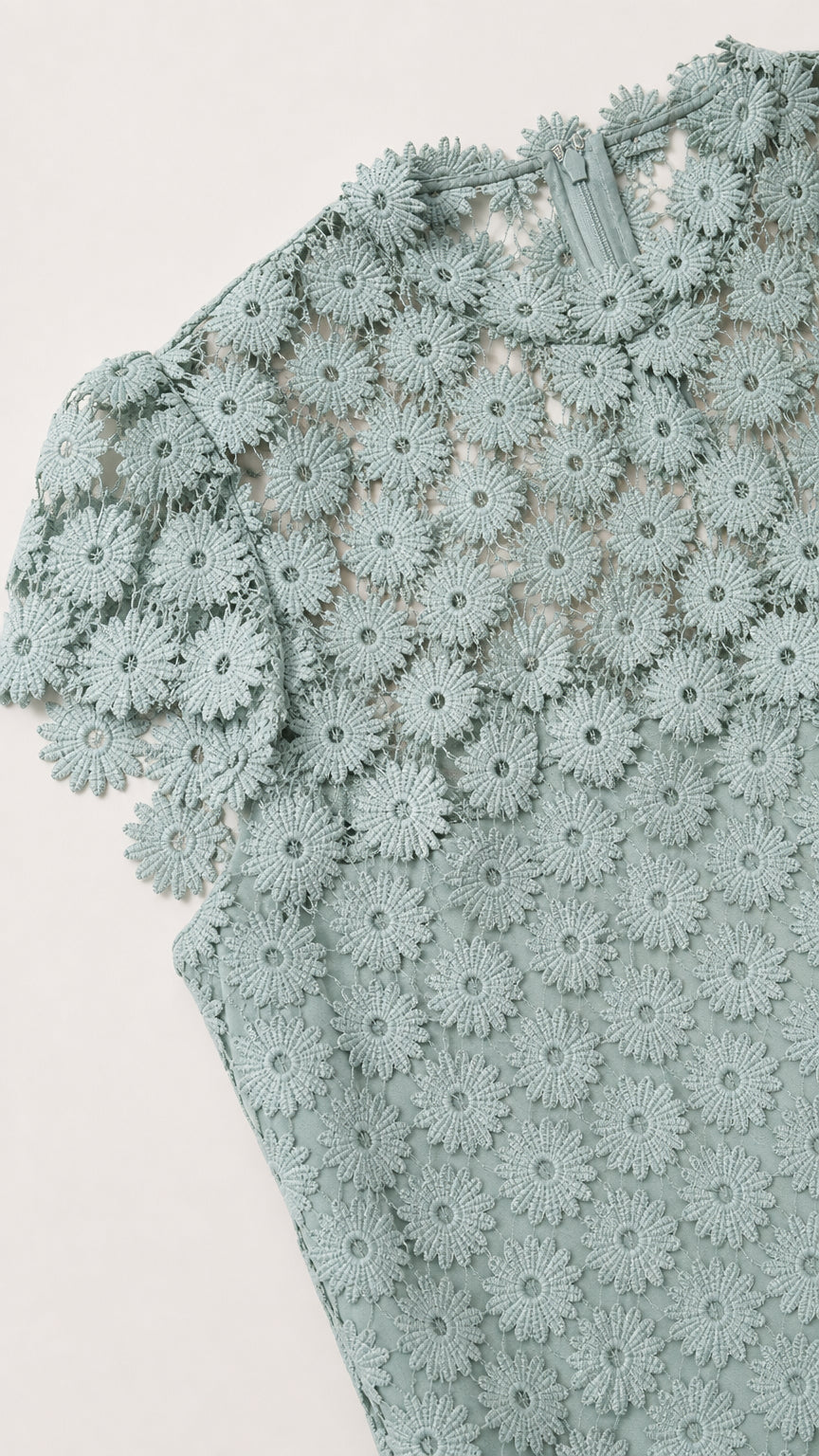 Close-up detail of sage green floral lace pattern and cap sleeve